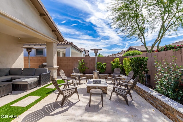 view of patio featuring an outdoor living space with a fire pit and a fenced backyard