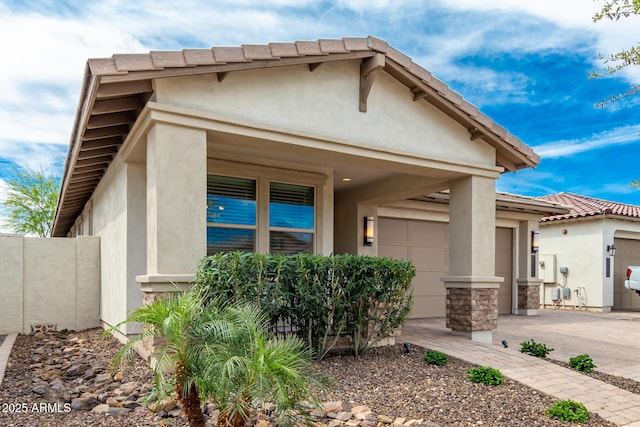 view of front of home with a garage, decorative driveway, and stucco siding