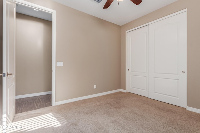 unfurnished bedroom featuring carpet flooring, ceiling fan, and a closet