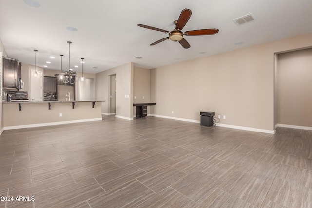 unfurnished living room featuring ceiling fan, dark hardwood / wood-style flooring, and sink