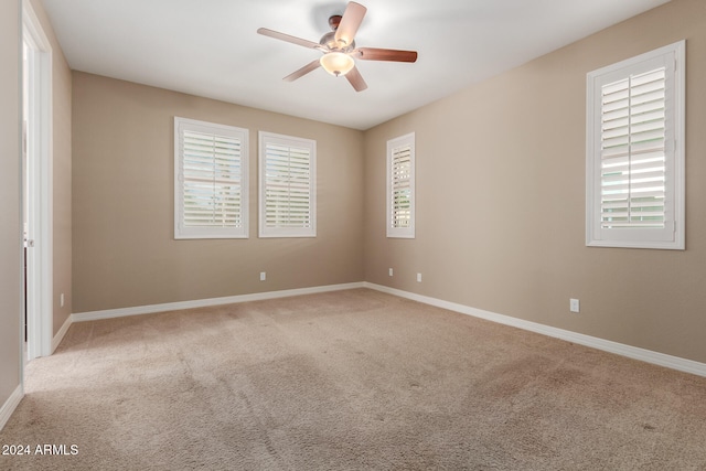 unfurnished room featuring light carpet, plenty of natural light, and ceiling fan