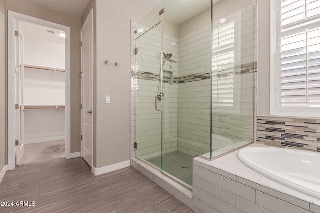 bathroom featuring hardwood / wood-style floors and plus walk in shower