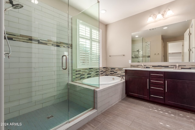 bathroom featuring shower with separate bathtub, vanity, and tile patterned floors