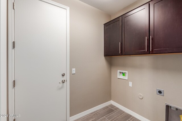 clothes washing area featuring cabinets, hookup for a washing machine, hookup for a gas dryer, and electric dryer hookup