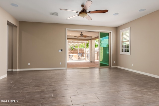 unfurnished room with ceiling fan and a healthy amount of sunlight