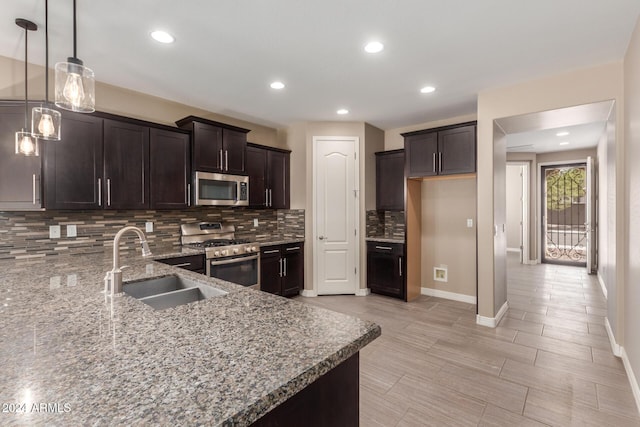 kitchen with pendant lighting, dark brown cabinetry, sink, and appliances with stainless steel finishes