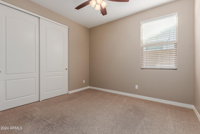 unfurnished bedroom with ceiling fan, a closet, and carpet floors