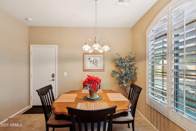 tiled dining area with a chandelier