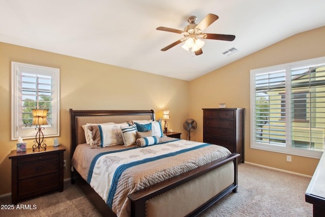 bedroom with ceiling fan, vaulted ceiling, carpet floors, and multiple windows