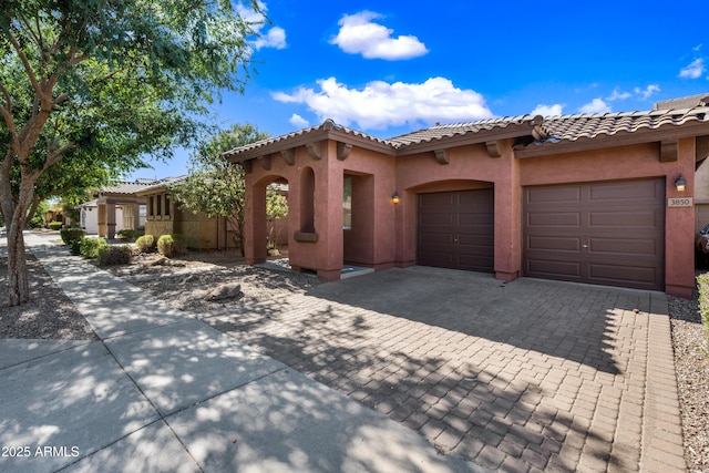 3850 E Geronimo St, Gilbert, AZ 85295 - mediterranean / spanish house with decorative driveway, a garage, stucco siding, and a tiled roof