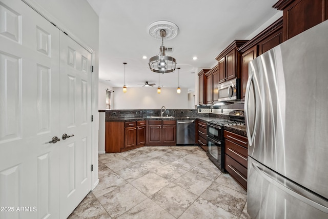 3850 E Geronimo St, Gilbert, AZ 85295 - kitchen with appliances with stainless steel finishes, hanging light fixtures, dark stone counters, a ceiling fan, and recessed lighting