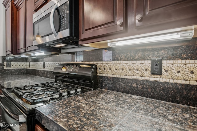 3850 E Geronimo St, Gilbert, AZ 85295 - kitchen with stainless steel microwave, black gas range, tile countertops, tasteful backsplash, and dark brown cabinets