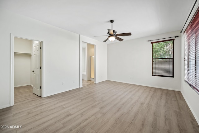 3850 E Geronimo St, Gilbert, AZ 85295 - unfurnished bedroom featuring light wood-style flooring, a walk in closet, a ceiling fan, and a closet