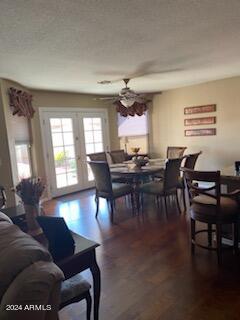 dining area with ceiling fan, dark hardwood / wood-style flooring, a textured ceiling, and french doors