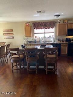 kitchen featuring dark wood-type flooring and black appliances