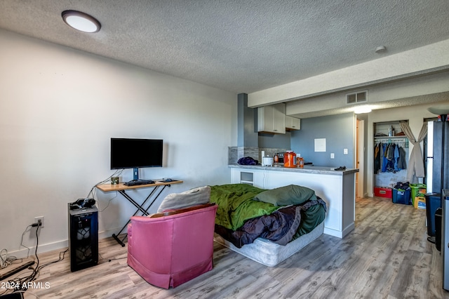 living room with a textured ceiling and wood-type flooring