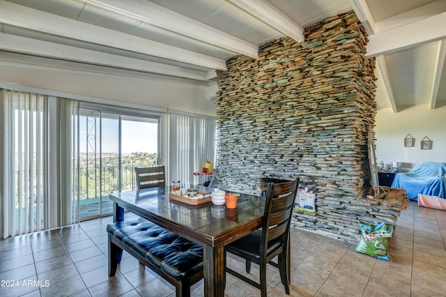 tiled dining space featuring beam ceiling