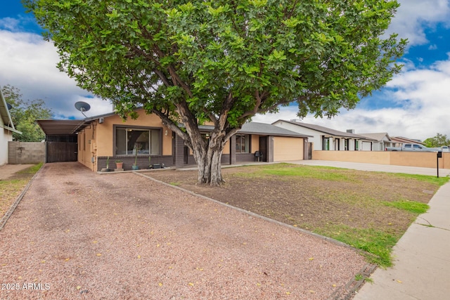 7755 W Cora Ln, Phoenix, AZ 85033 - view of front facade featuring driveway, an attached garage, stucco siding, and fence