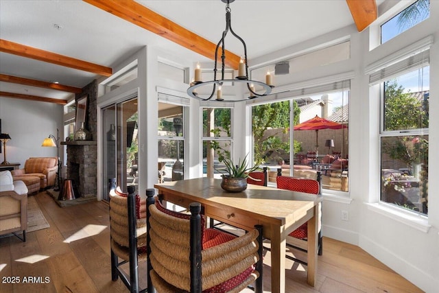 dining space featuring beamed ceiling, hardwood / wood-style floors, and a wealth of natural light