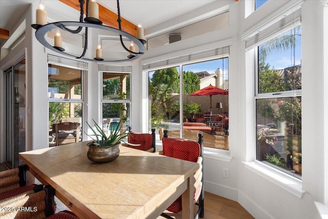 sunroom / solarium featuring plenty of natural light and a notable chandelier