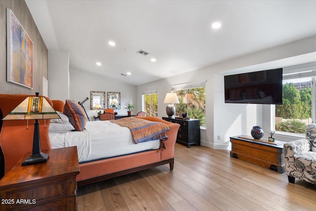 bedroom featuring multiple windows, light hardwood / wood-style flooring, and vaulted ceiling