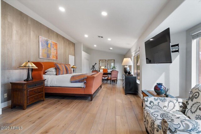 bedroom featuring multiple windows, light hardwood / wood-style floors, and vaulted ceiling