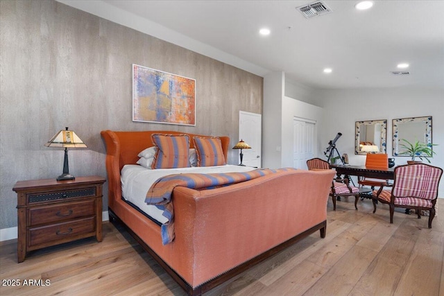 bedroom with a closet, vaulted ceiling, and light wood-type flooring