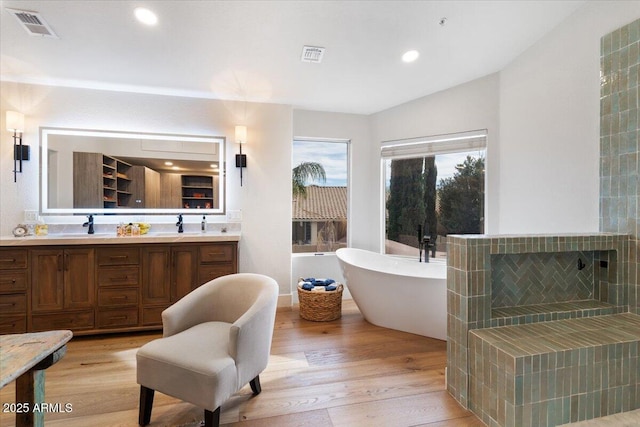 bathroom featuring hardwood / wood-style floors, vanity, and a tub