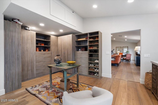 office with built in shelves, light hardwood / wood-style floors, and lofted ceiling