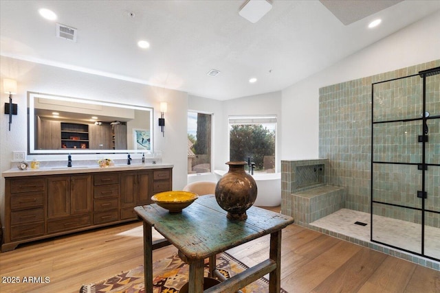 bathroom with hardwood / wood-style floors, vanity, vaulted ceiling, and shower with separate bathtub