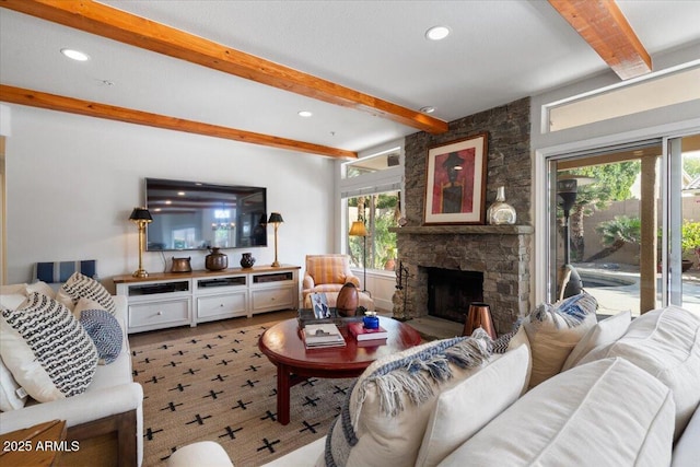 living room featuring a fireplace, beamed ceiling, and plenty of natural light