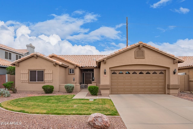 view of front of property with a garage, driveway, a tiled roof, a front lawn, and stucco siding