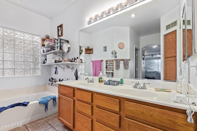 bathroom with tile patterned flooring, a bathtub, vanity, and a healthy amount of sunlight