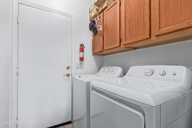 laundry area with washing machine and dryer and cabinets