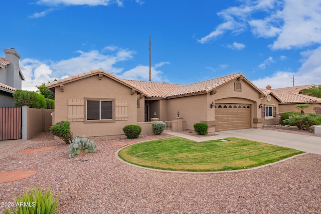 mediterranean / spanish home featuring stucco siding, concrete driveway, fence, a garage, and a tiled roof