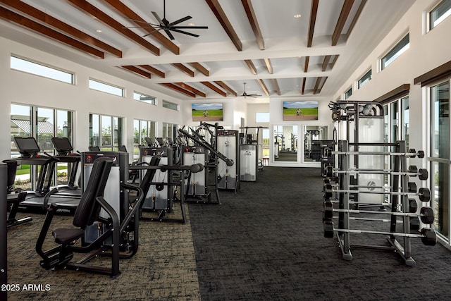 workout area with a high ceiling, ceiling fan, and dark colored carpet