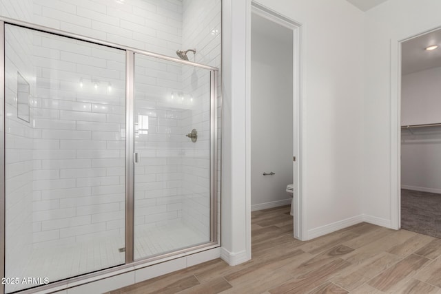 11660 W Luxton Ln, Avondale, AZ 85323 - bathroom with wood finished floors, a stall shower, toilet, and baseboards