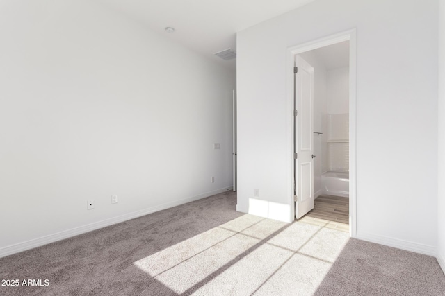 11660 W Luxton Ln, Avondale, AZ 85323 - unfurnished bedroom featuring light carpet, baseboards, and connected bathroom