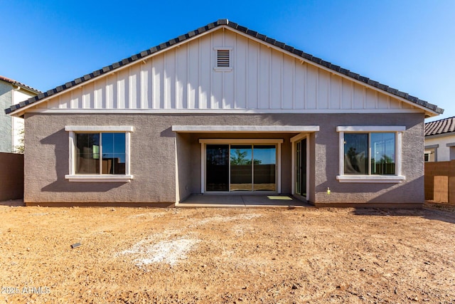 11660 W Luxton Ln, Avondale, AZ 85323 - rear view of house featuring board and batten siding, a tiled roof, a patio, and stucco siding
