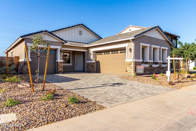 11660 W Luxton Ln, Avondale, AZ 85323 - craftsman-style home featuring stone siding, an attached garage, decorative driveway, and stucco siding