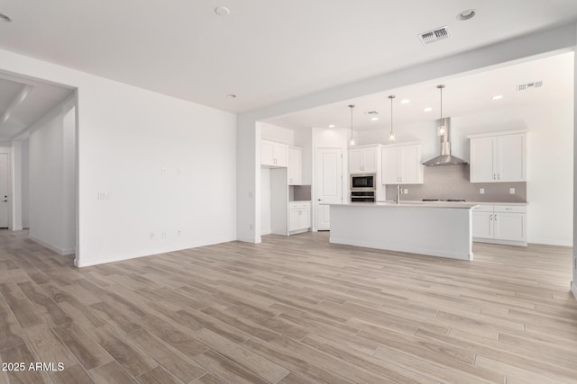 11660 W Luxton Ln, Avondale, AZ 85323 - kitchen with wall chimney exhaust hood, built in microwave, decorative backsplash, light wood-style flooring, and recessed lighting