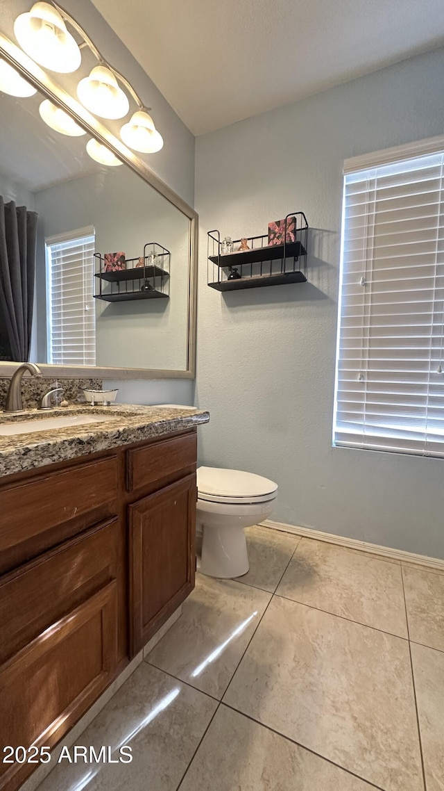 bathroom featuring vanity, tile patterned flooring, and toilet