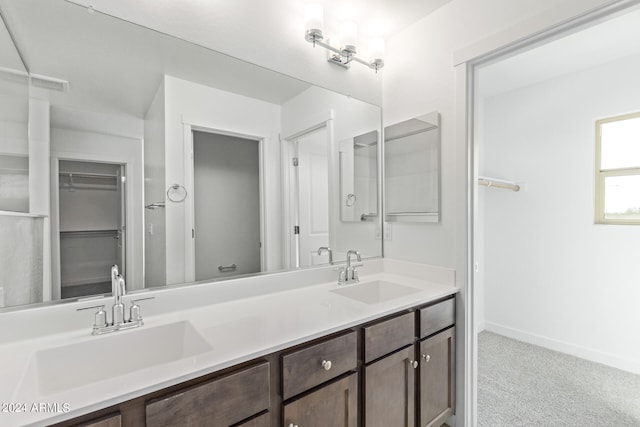 bathroom featuring dual sinks and vanity with extensive cabinet space