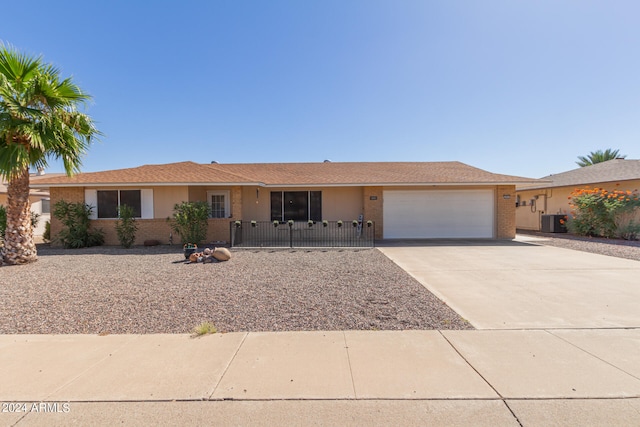 single story home with cooling unit and a garage