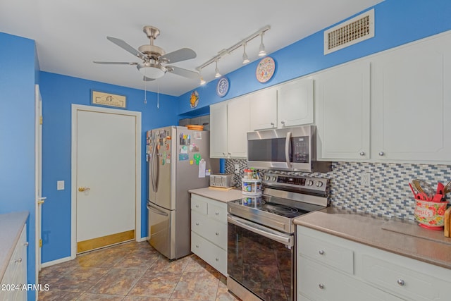 kitchen with white cabinets, backsplash, appliances with stainless steel finishes, tile patterned floors, and ceiling fan