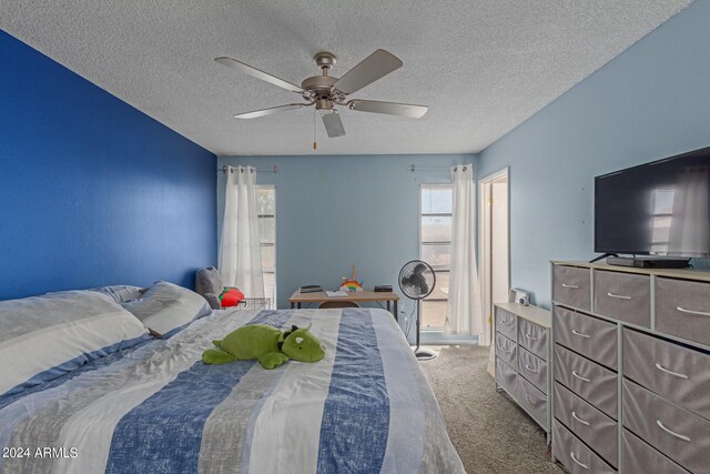 bedroom featuring ceiling fan, a textured ceiling, and carpet flooring