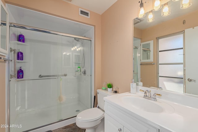 bathroom featuring vanity, toilet, tile patterned floors, and a shower with door