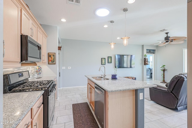 kitchen with sink, light brown cabinets, an island with sink, pendant lighting, and appliances with stainless steel finishes