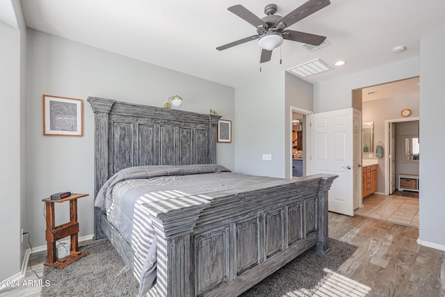 bedroom featuring connected bathroom, light hardwood / wood-style floors, and ceiling fan