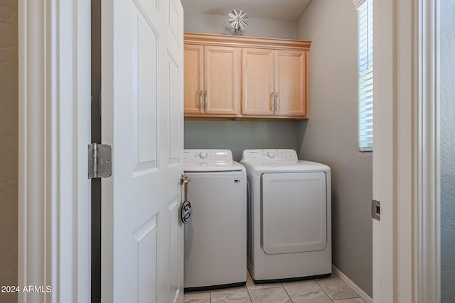 laundry room featuring washer and clothes dryer, cabinets, and light tile patterned floors